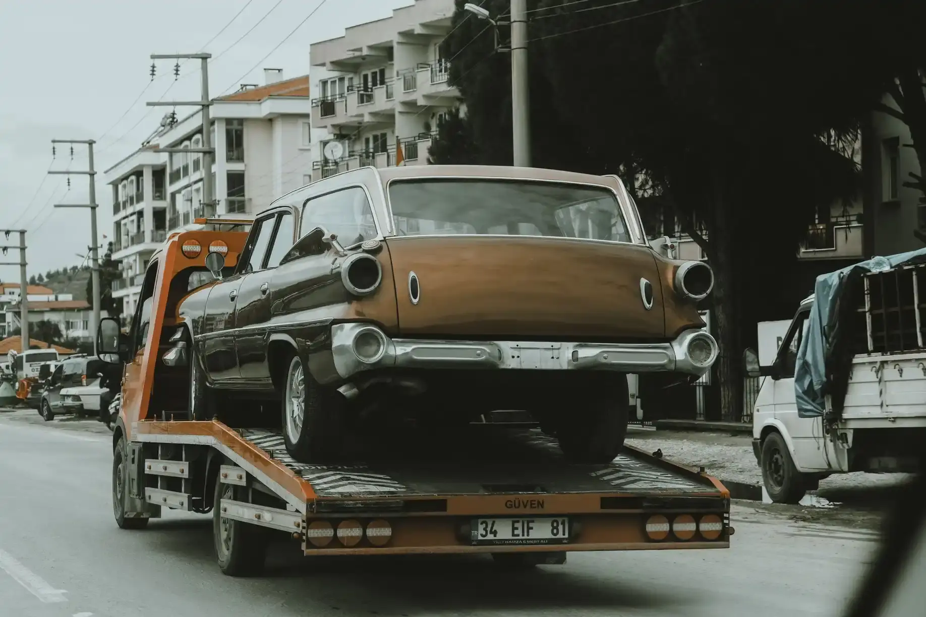 Tow truck driver loading a pickup onto a flatbed for free removal