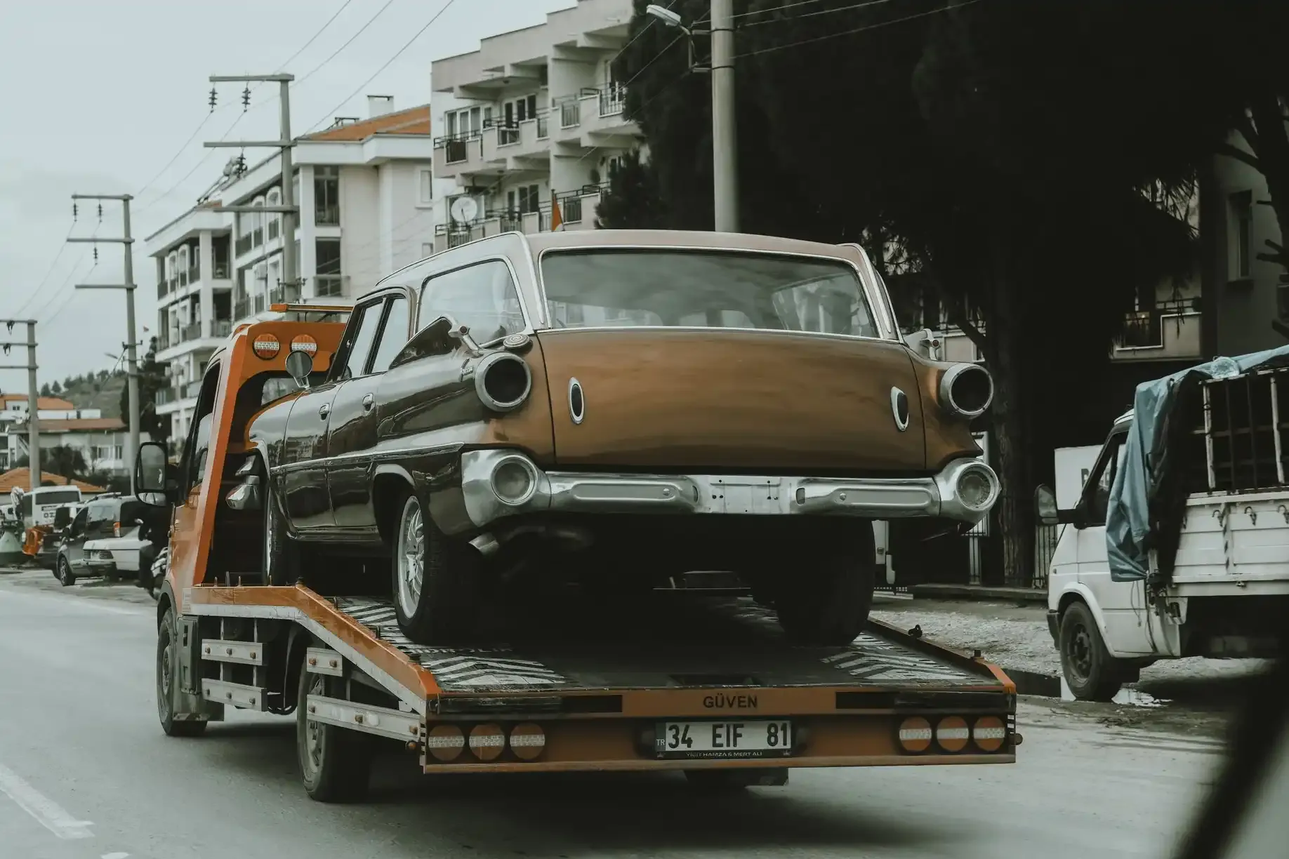Tow truck driver loading a pickup onto a flatbed for free removal