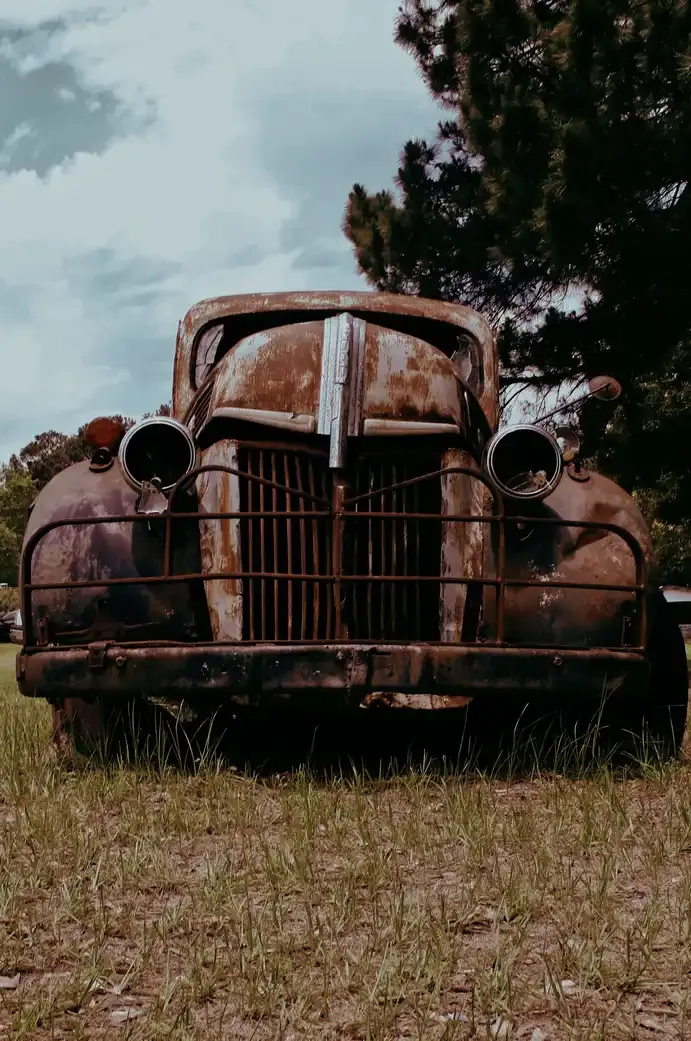 An old, weathered car left sitting unused